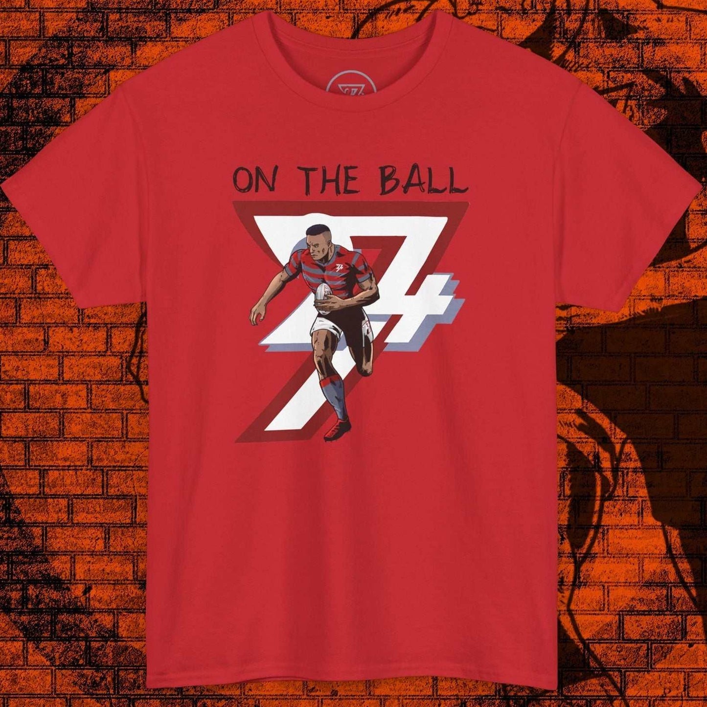 Red rugby sports tee with hand-drawn player illustration and "On The Ball" text, sporty casual wear