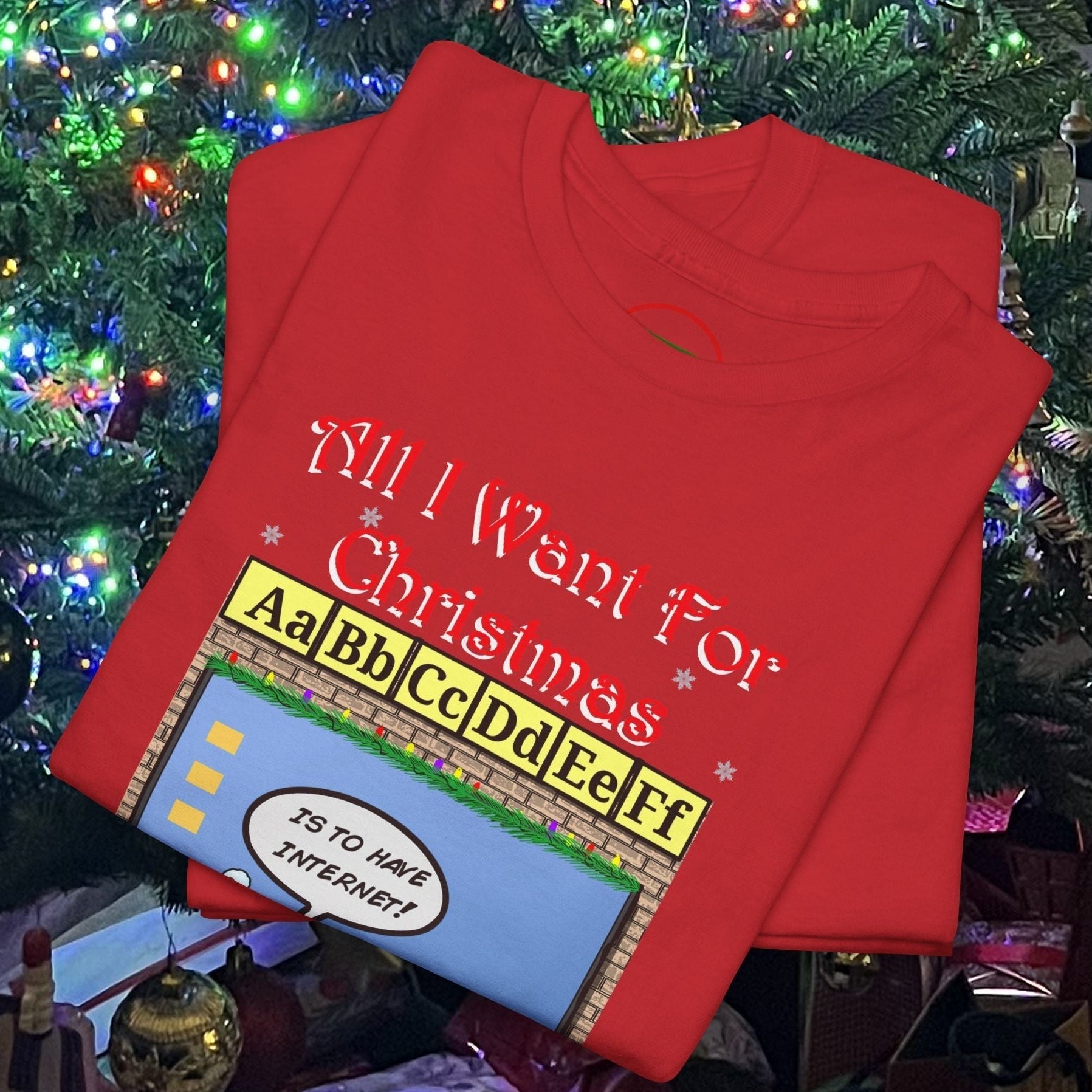 Red teacher elf t-shirt with humorous Christmas design folded under decorated holiday tree lights