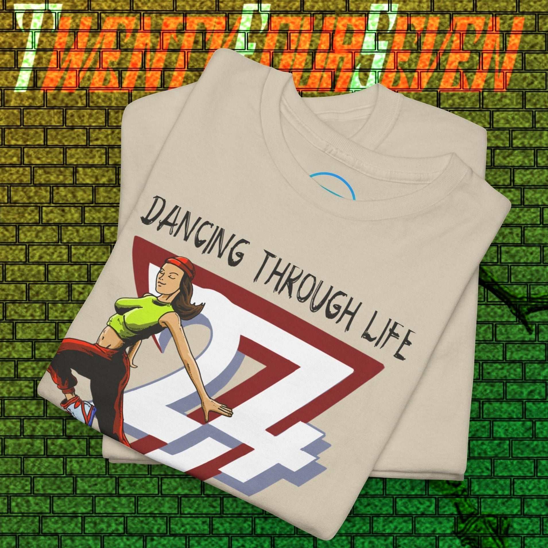 Street Dance Graphic Tee with vibrant hand-drawn dancer and urban style text on beige fabric, folded on green brick background