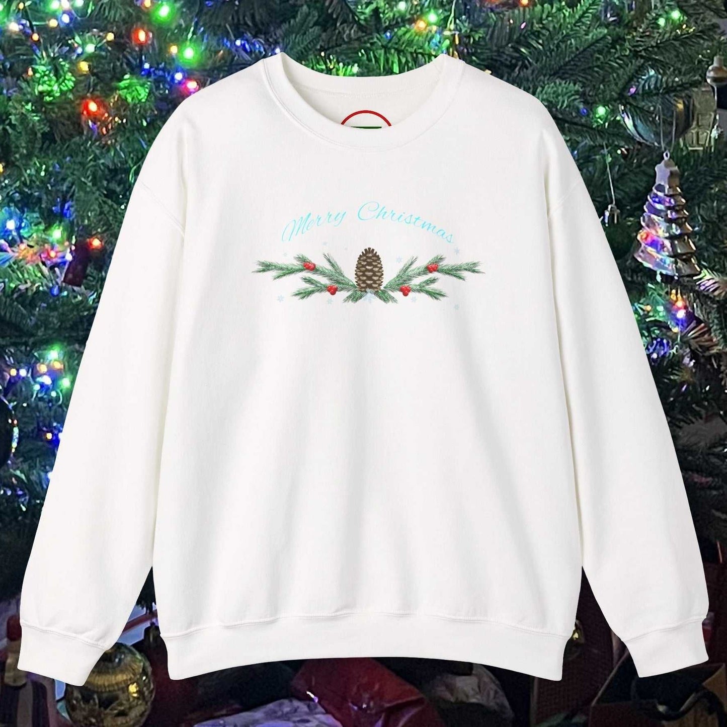 White Pinecone Christmas Sweatshirt with festive pinecone and greenery design in front of decorated Christmas tree