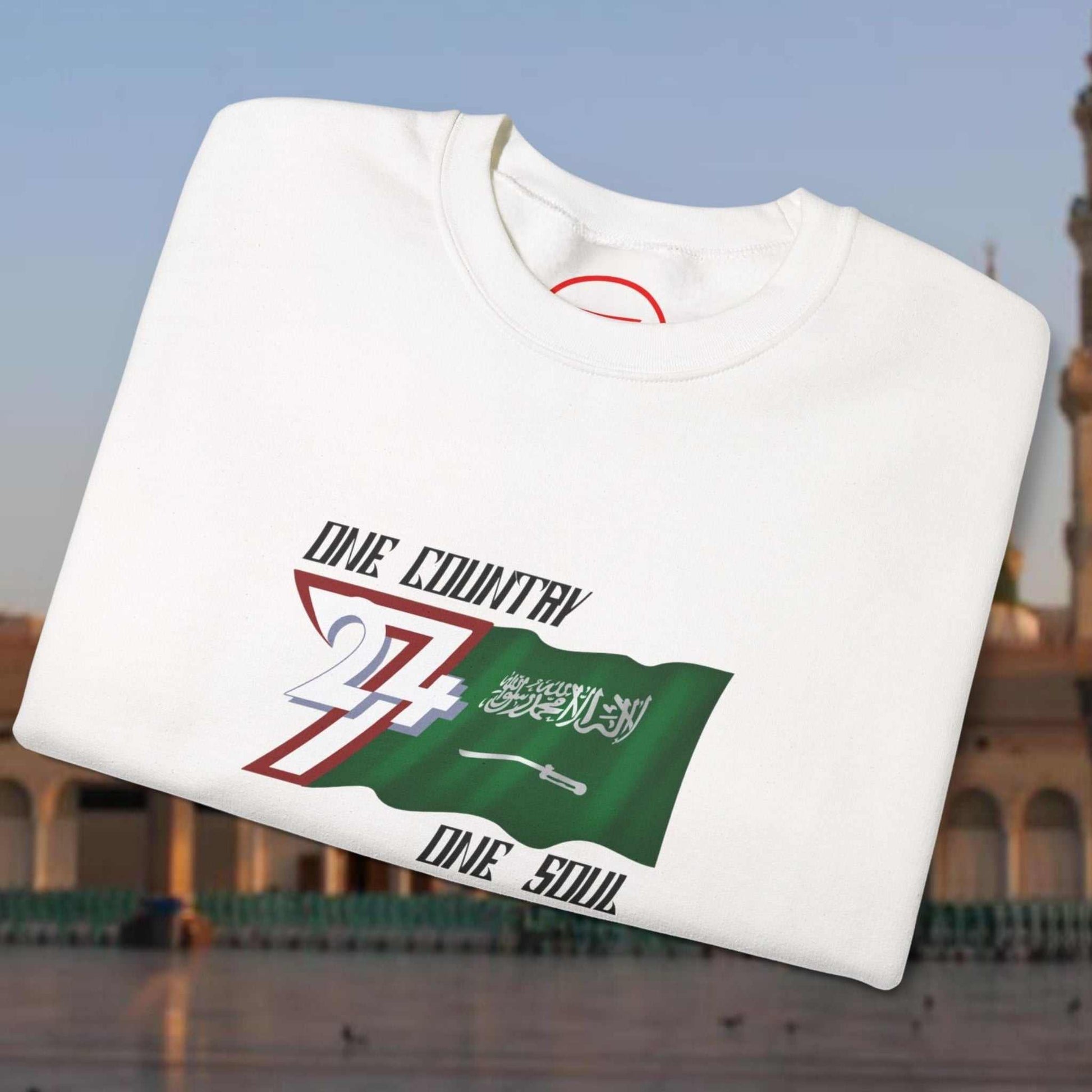 White Saudi Arabia flag crewneck sweatshirt with vibrant hand-drawn patriotic design and slogan "One Country One Soul"