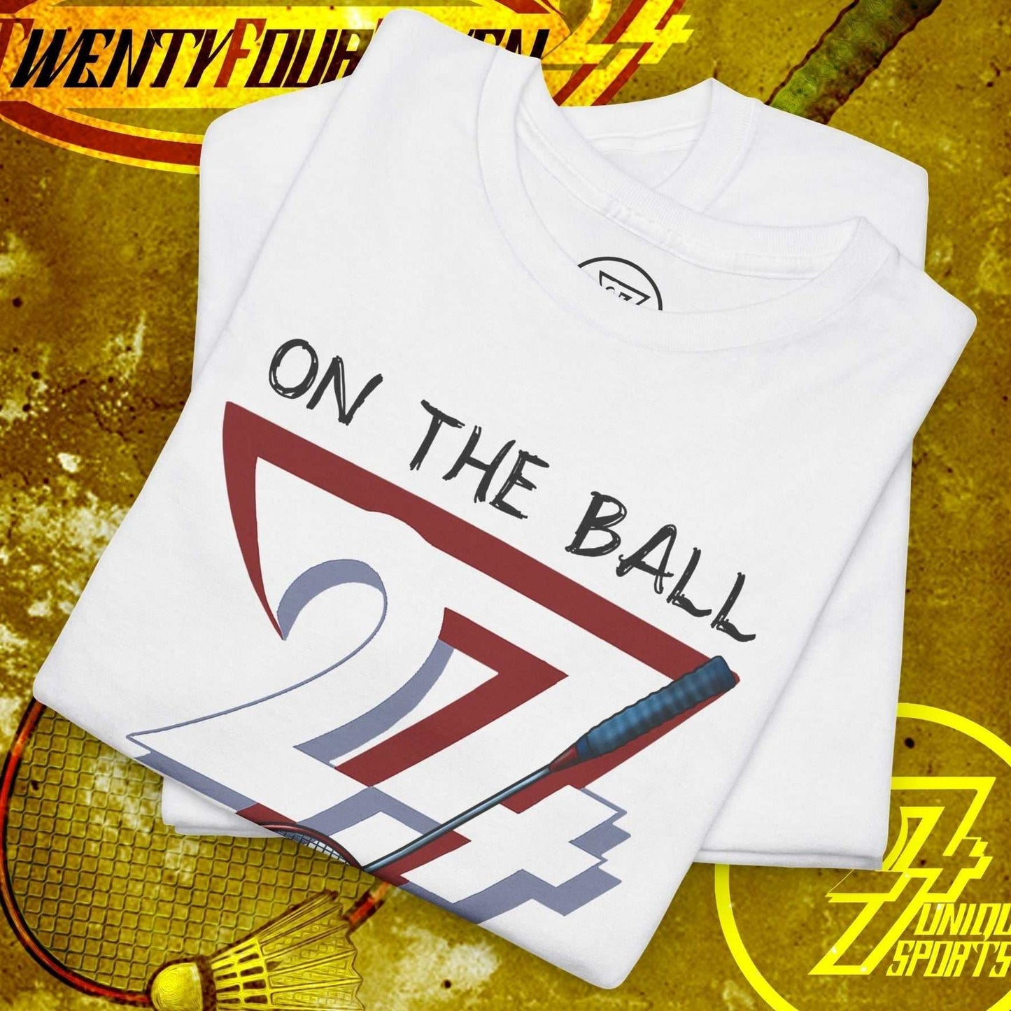White badminton tee with hand-drawn "On The Ball 24/7" graphic, folded on a yellow badminton-themed background