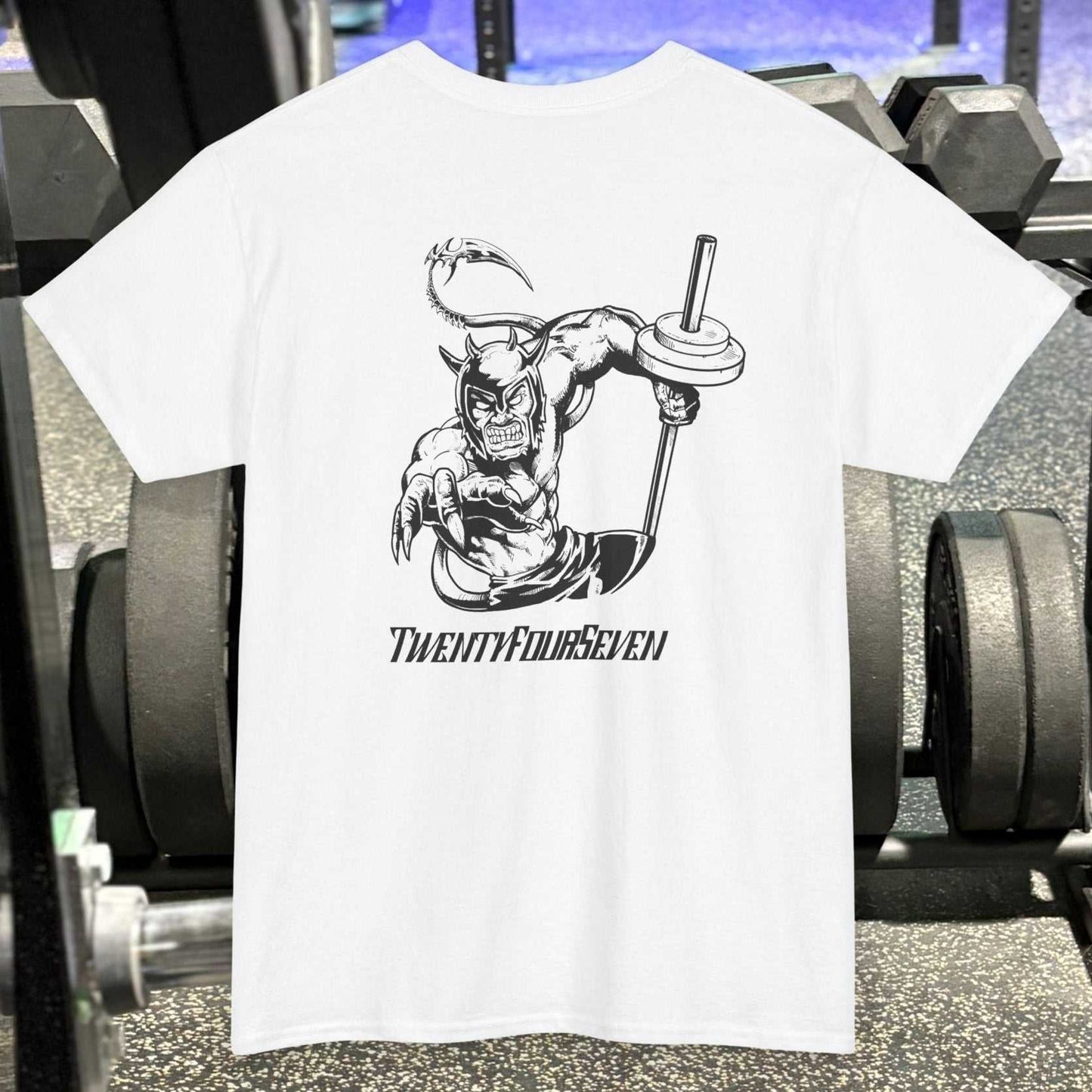 White bodybuilding tee with black comic-style muscular character holding a barbell and "TwentyFourSeven" text on gym background