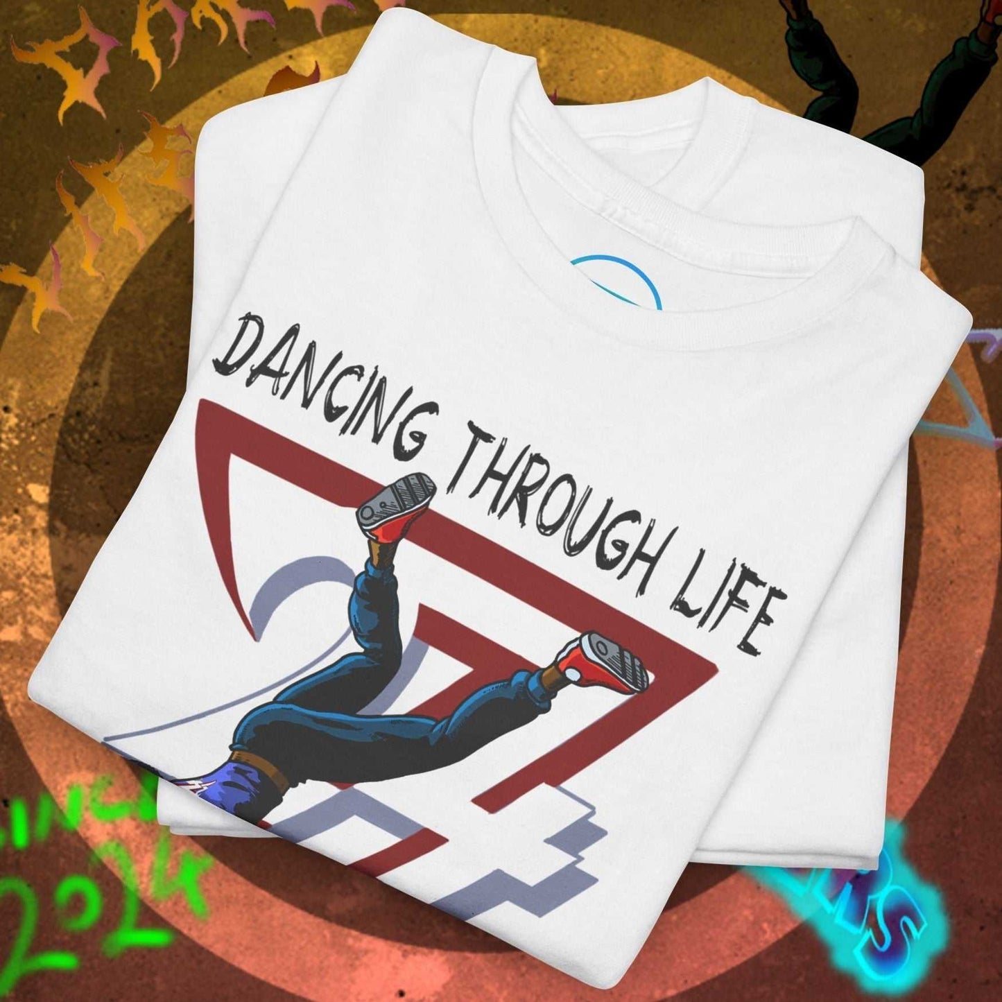 White dance tee with hip-hop graphic and "Dancing Through Life" text, folded on urban background
