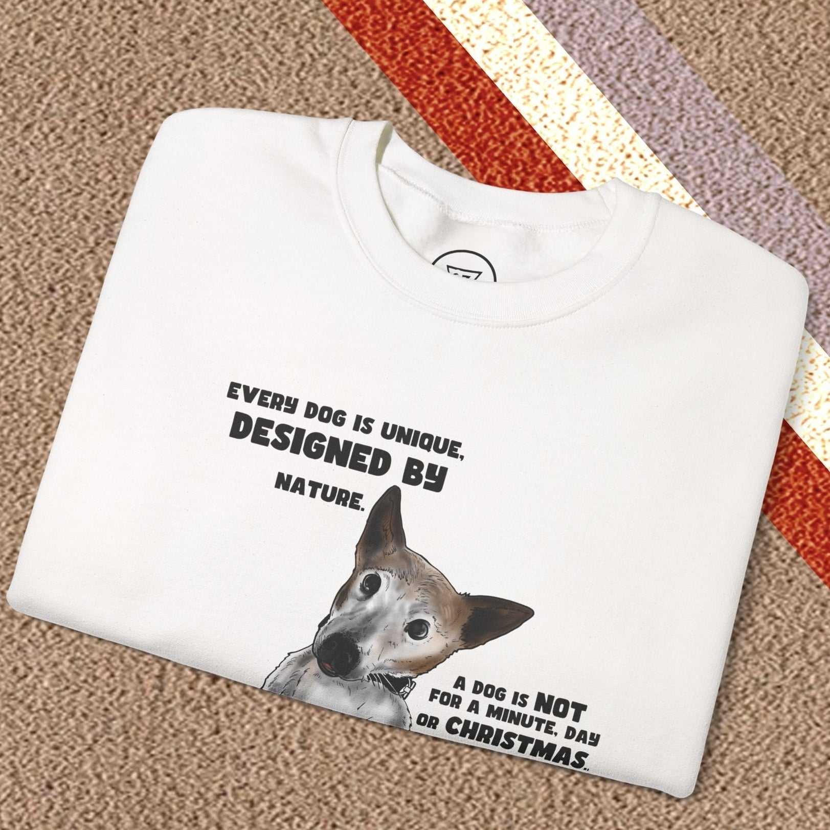 White dog lover sweatshirt with Jack Russel design and black text, folded on a textured surface with striped background.