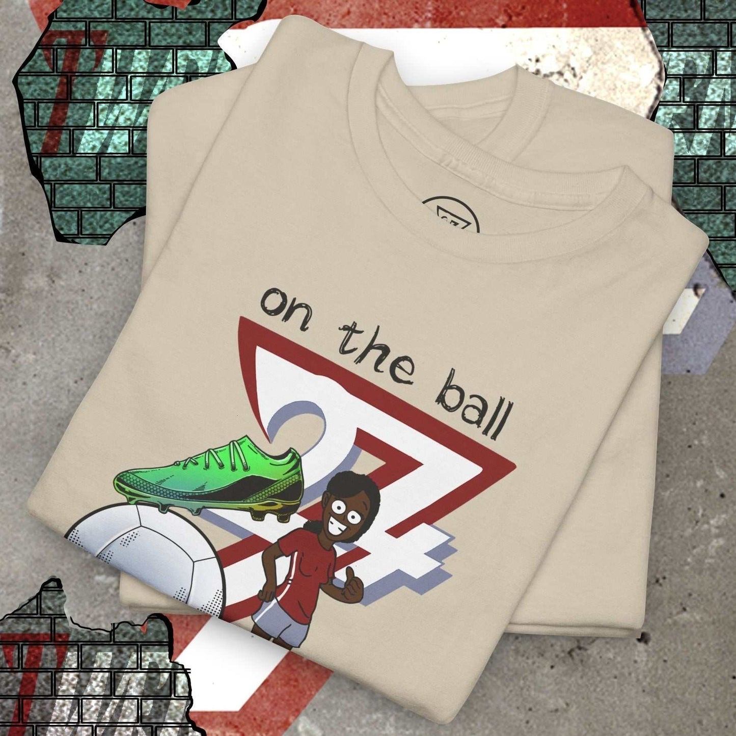 Women's football boot tee with hand-drawn soccer boot graphic and "on the ball 24/7" design on beige cotton shirt.