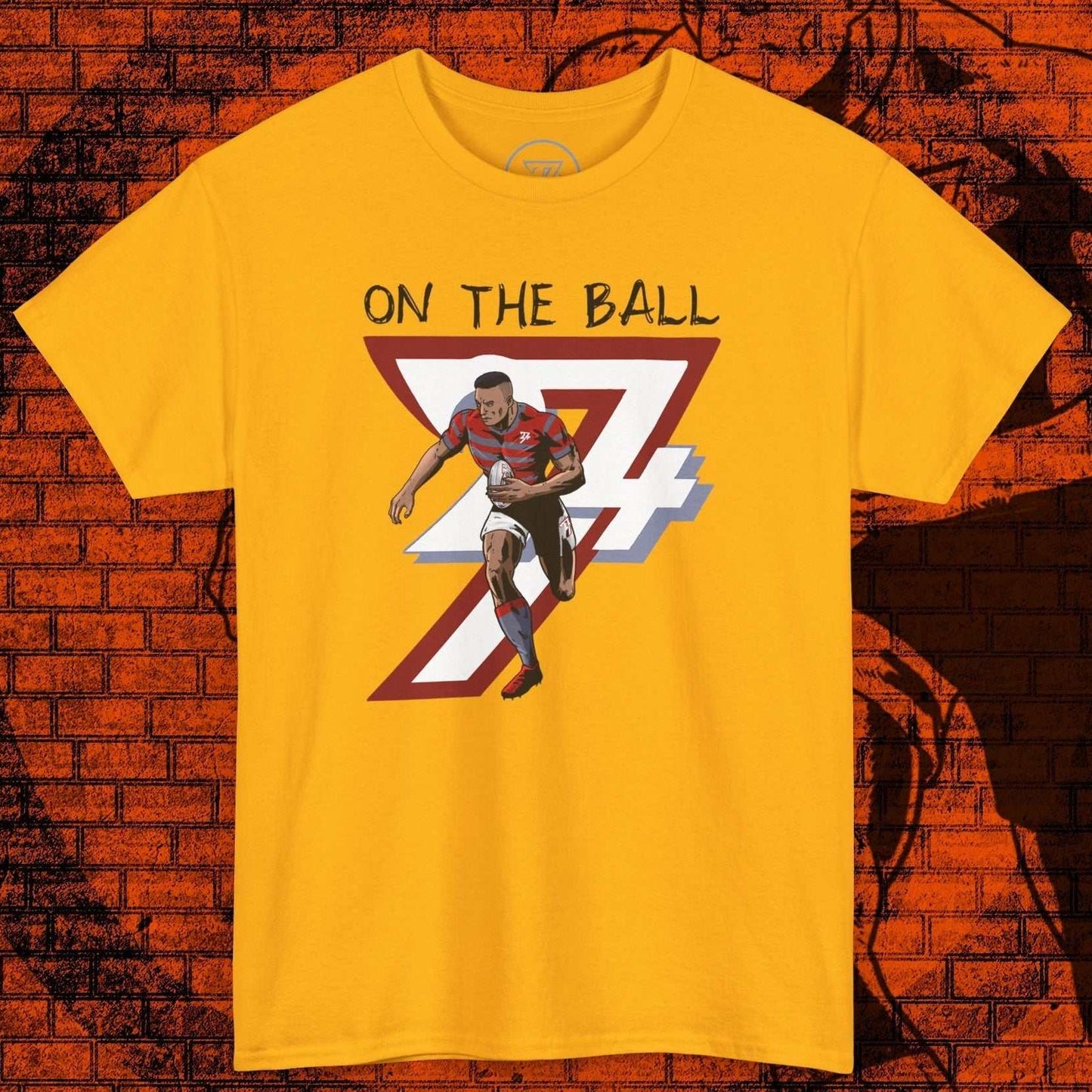 Yellow rugby sports tee with hand-drawn player illustration and "On The Ball" text in comic style