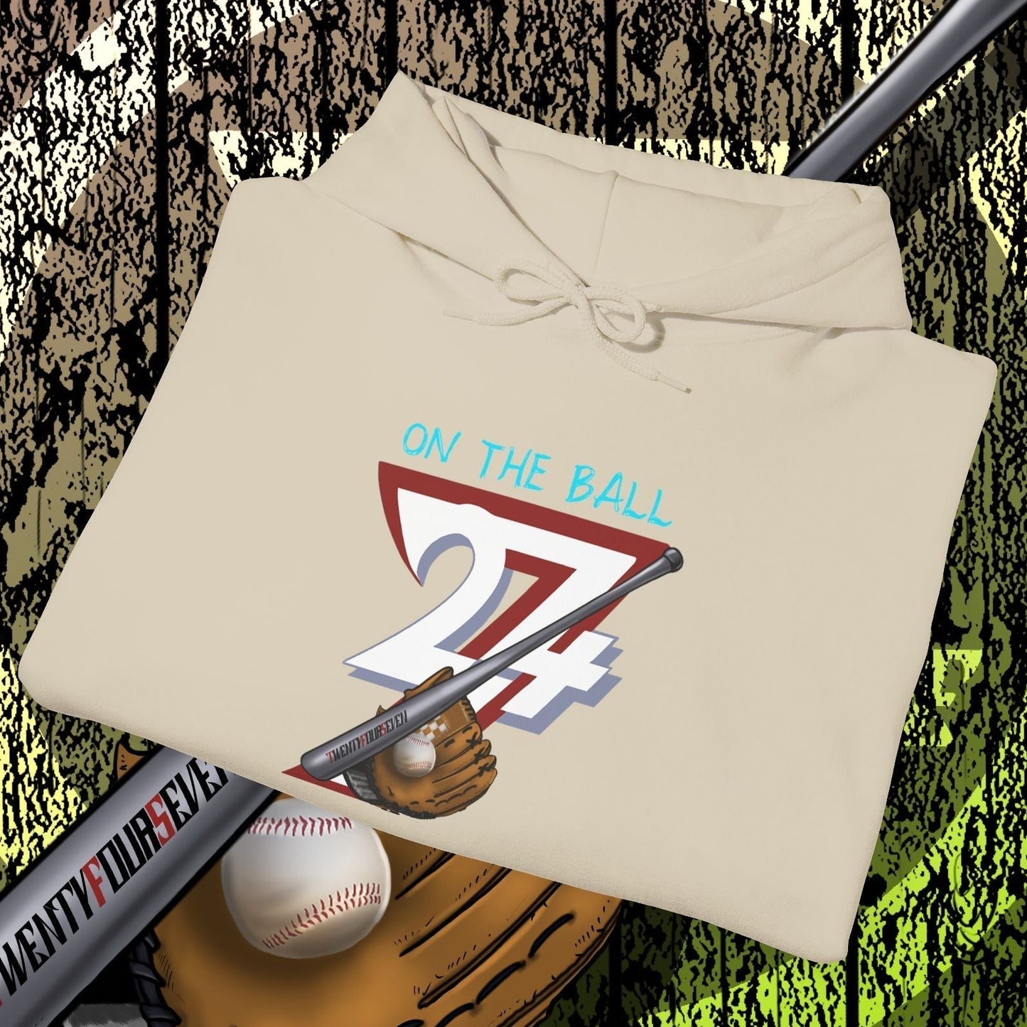 beige baseball hoodie with "On The Ball 24/7" graphic, baseball bat, glove, and ball on wooden background