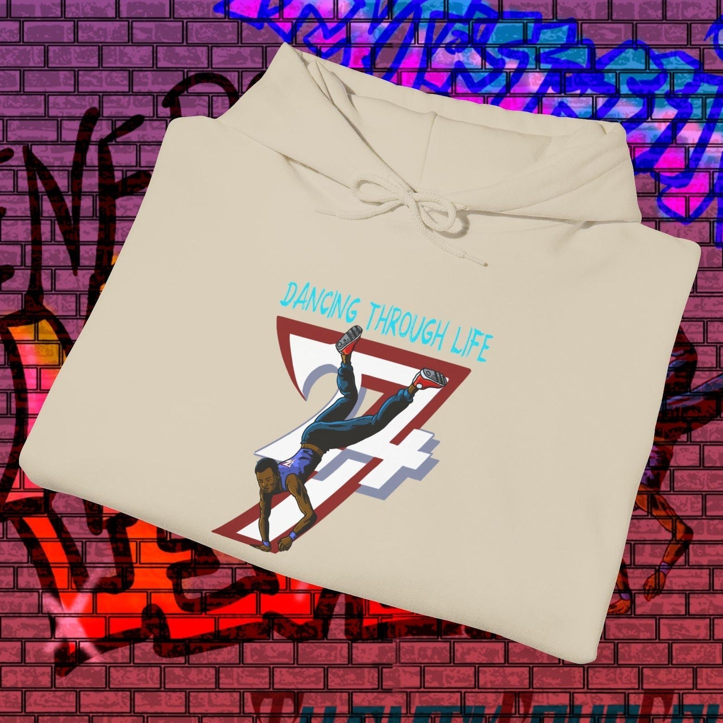 beige street dance hoodie with hand-drawn breakdancer and "Dancing Through Life" text on urban graffiti background