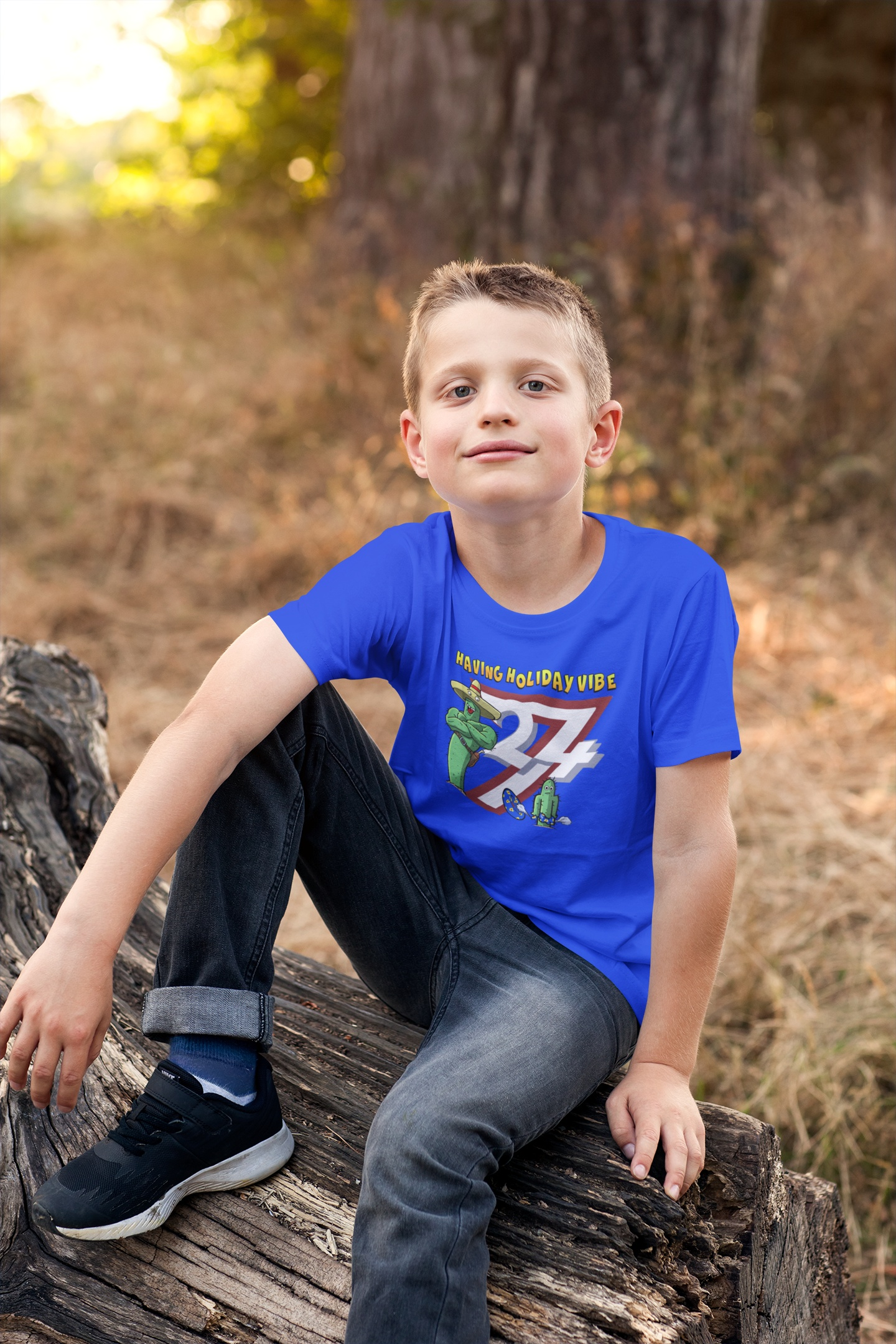 Young boy wearing the Royal Blue Kids Summer Vacation T-Shirt showcasing the original 24/7 characters.