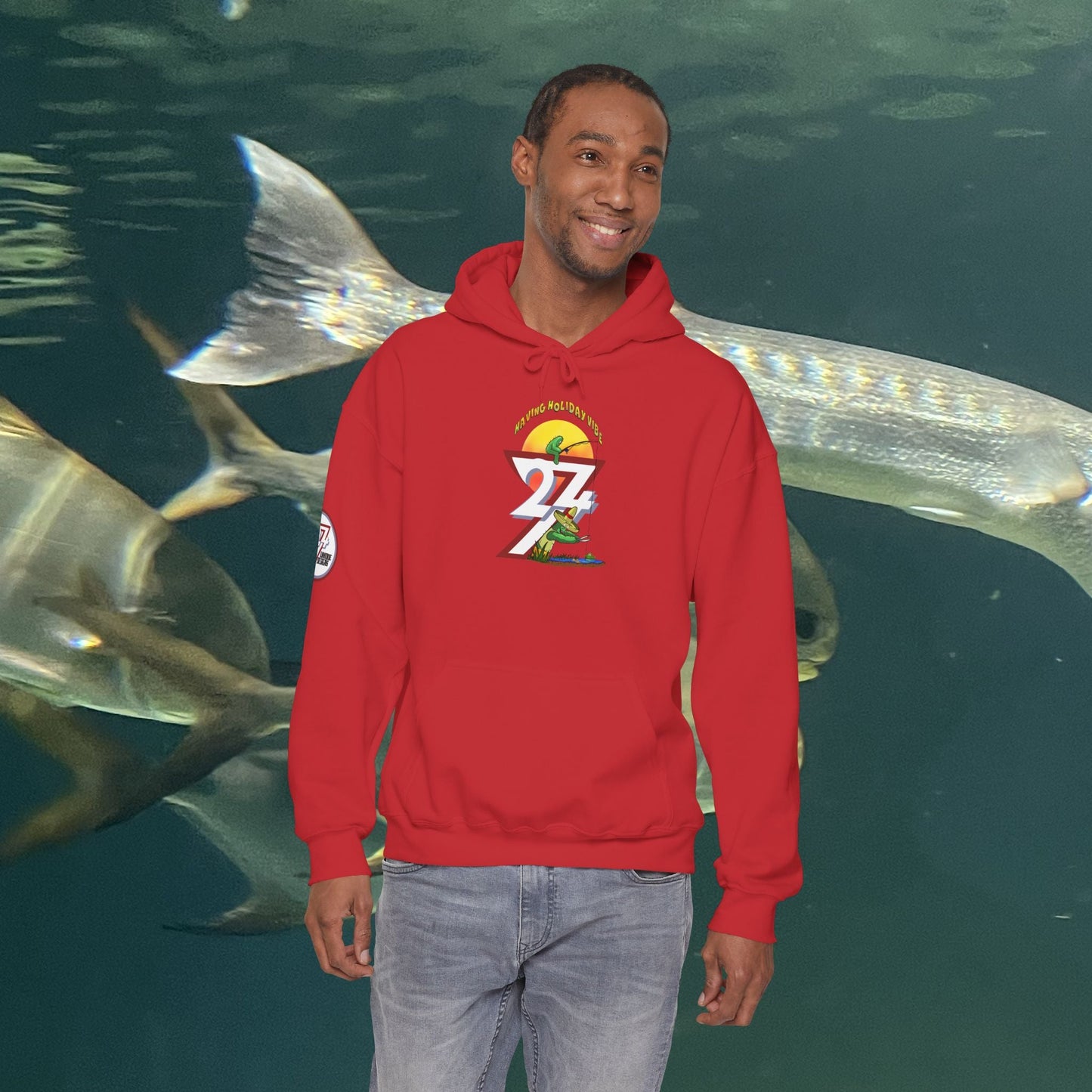 man wearing red Funny Fishing Hoodie with cactus design standing in front of aquarium fish background