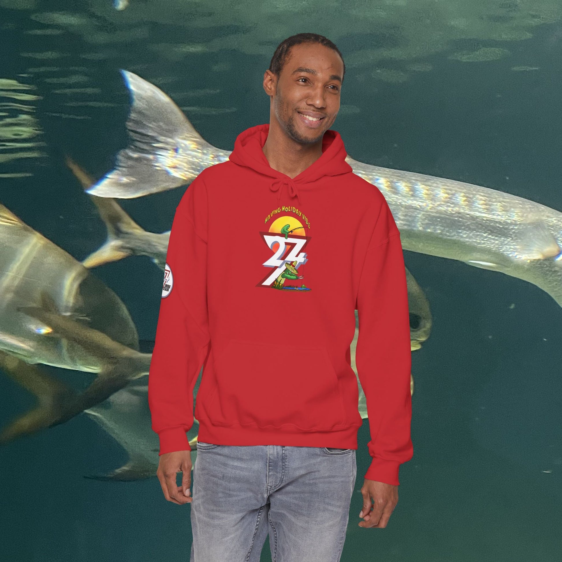 man wearing red Funny Fishing Hoodie with cactus design standing in front of aquarium fish background