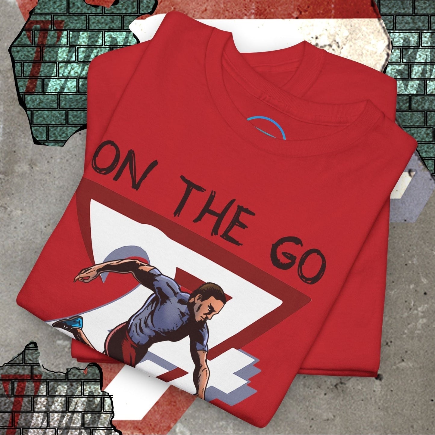 red running sports tee with hand-drawn runner illustration and "ON THE GO" text folded on concrete surface